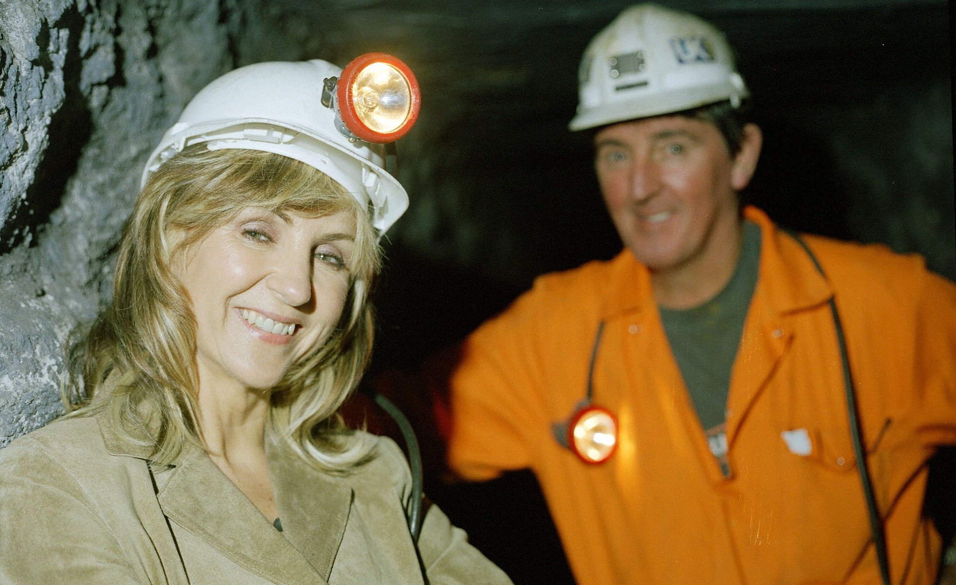 Lesley Garrett wearing a hard hat and headlamp in a mine.