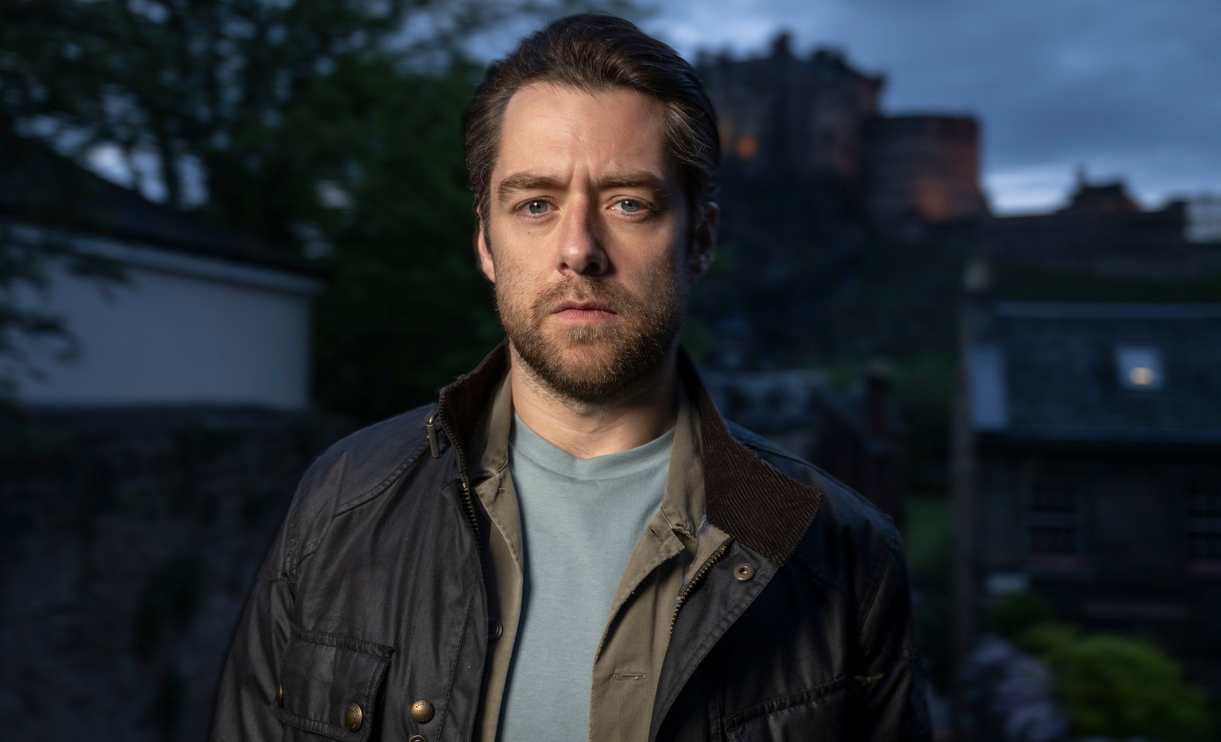 a man with a beard is wearing a black jacket