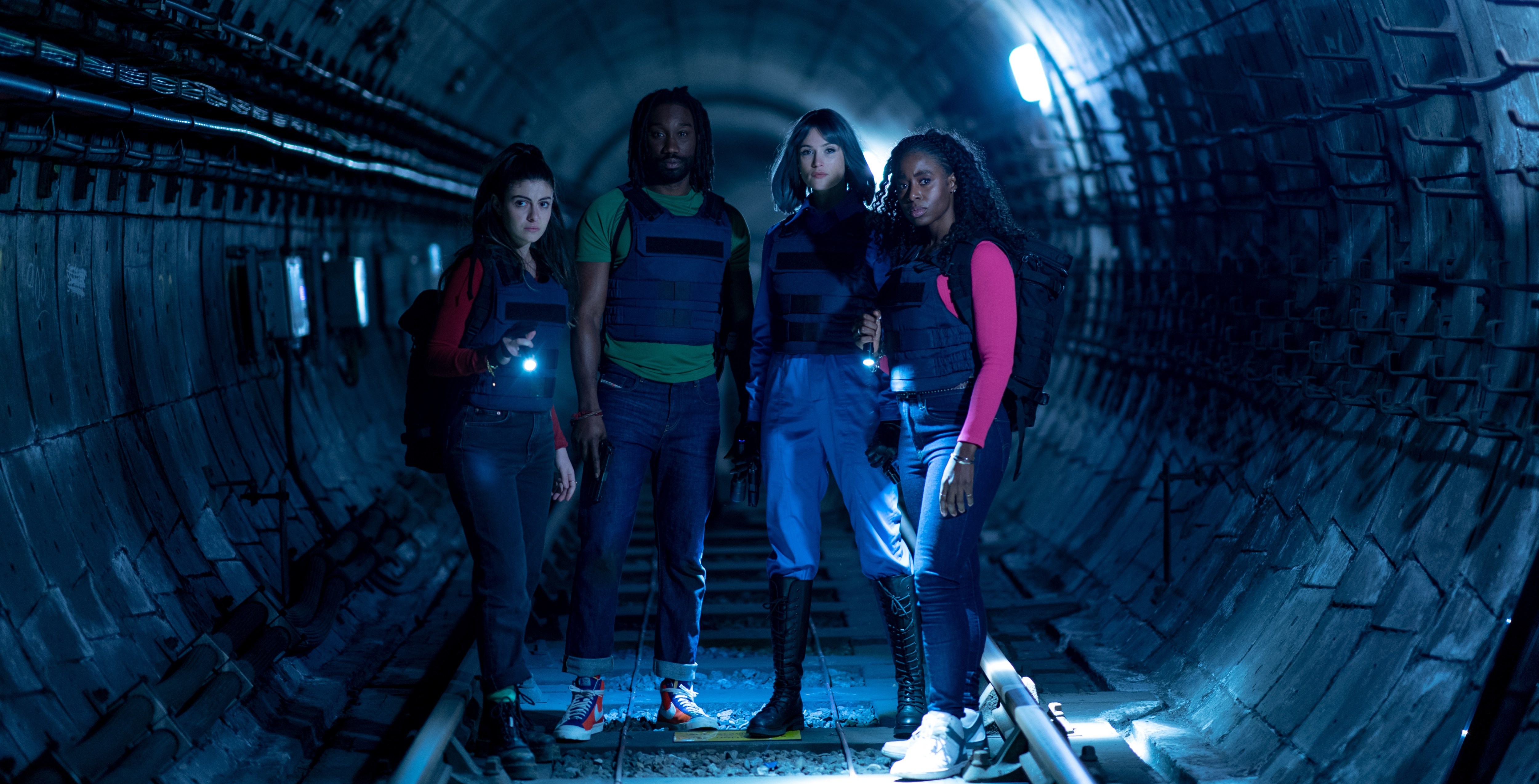 a group of people are standing in a dark tunnel