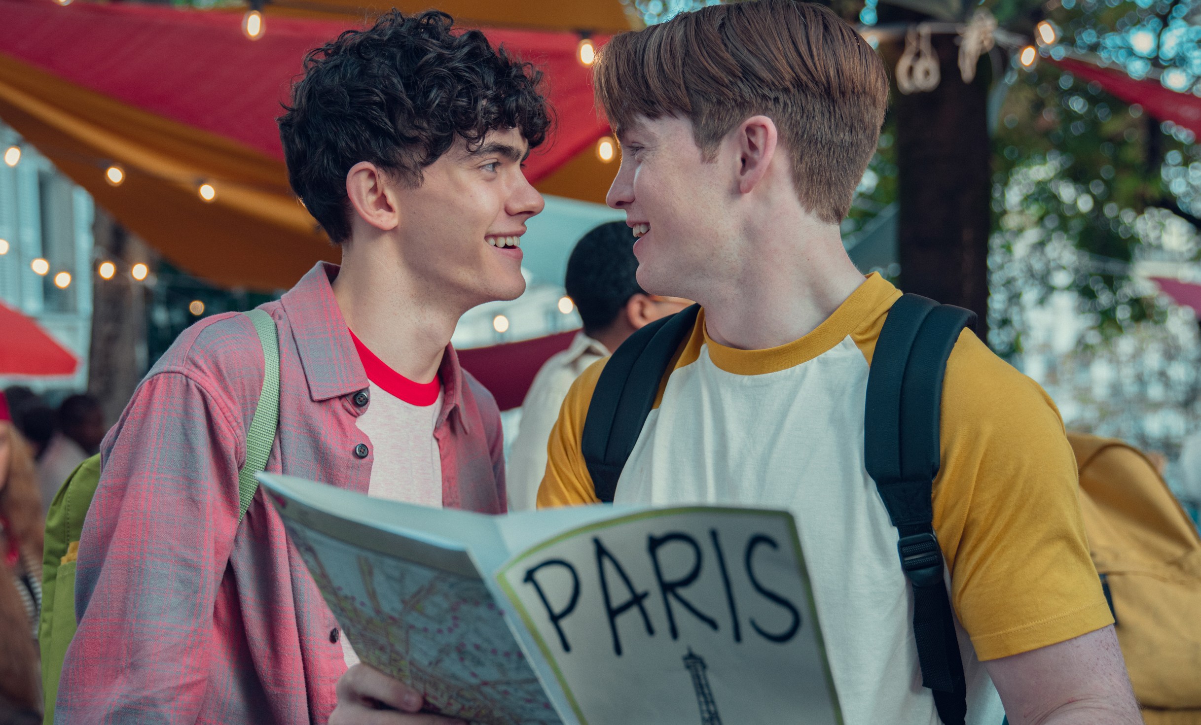 two young men are looking at a map of paris