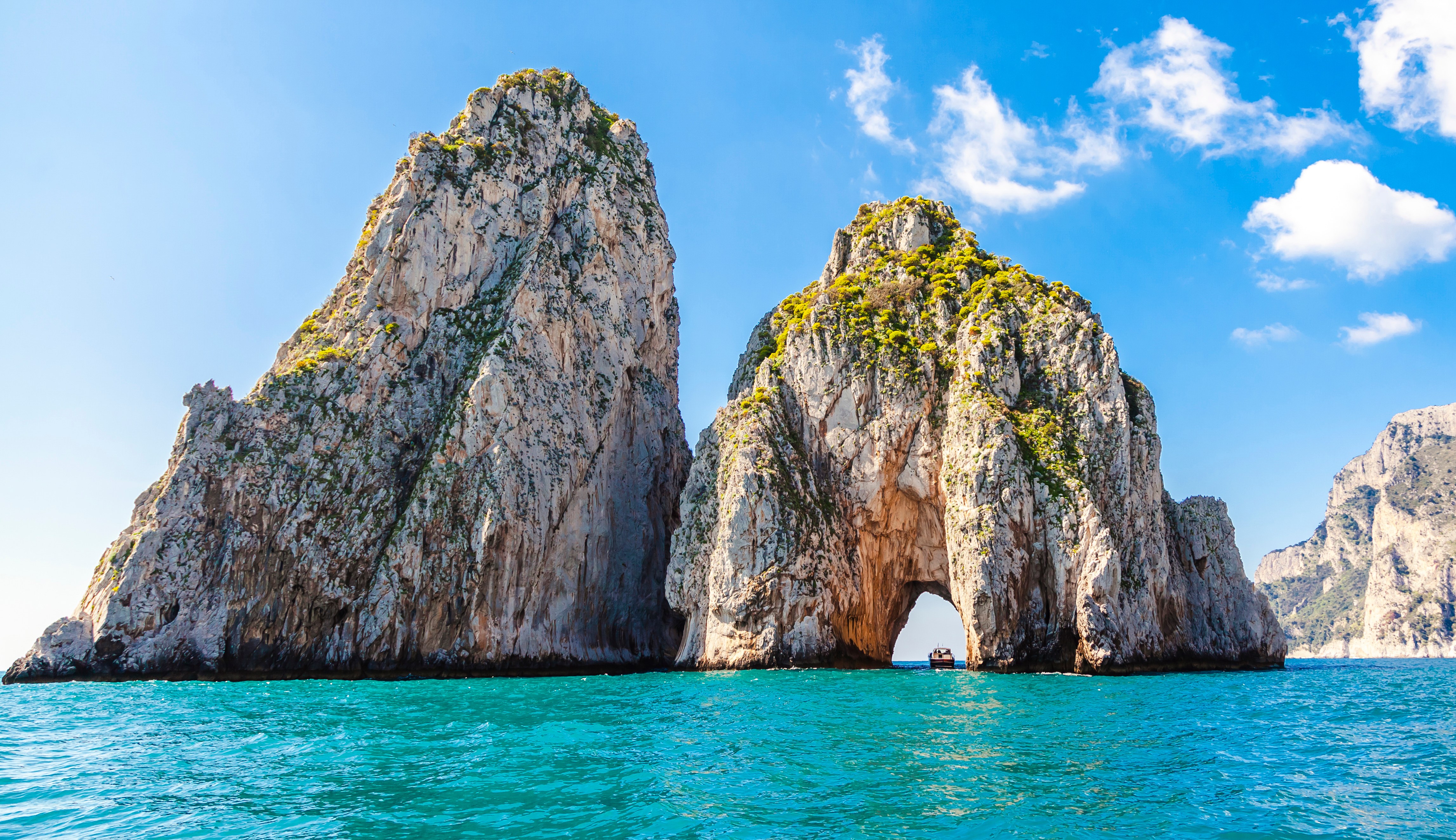 Coastal rock formations with an archway in Capri, Italy.