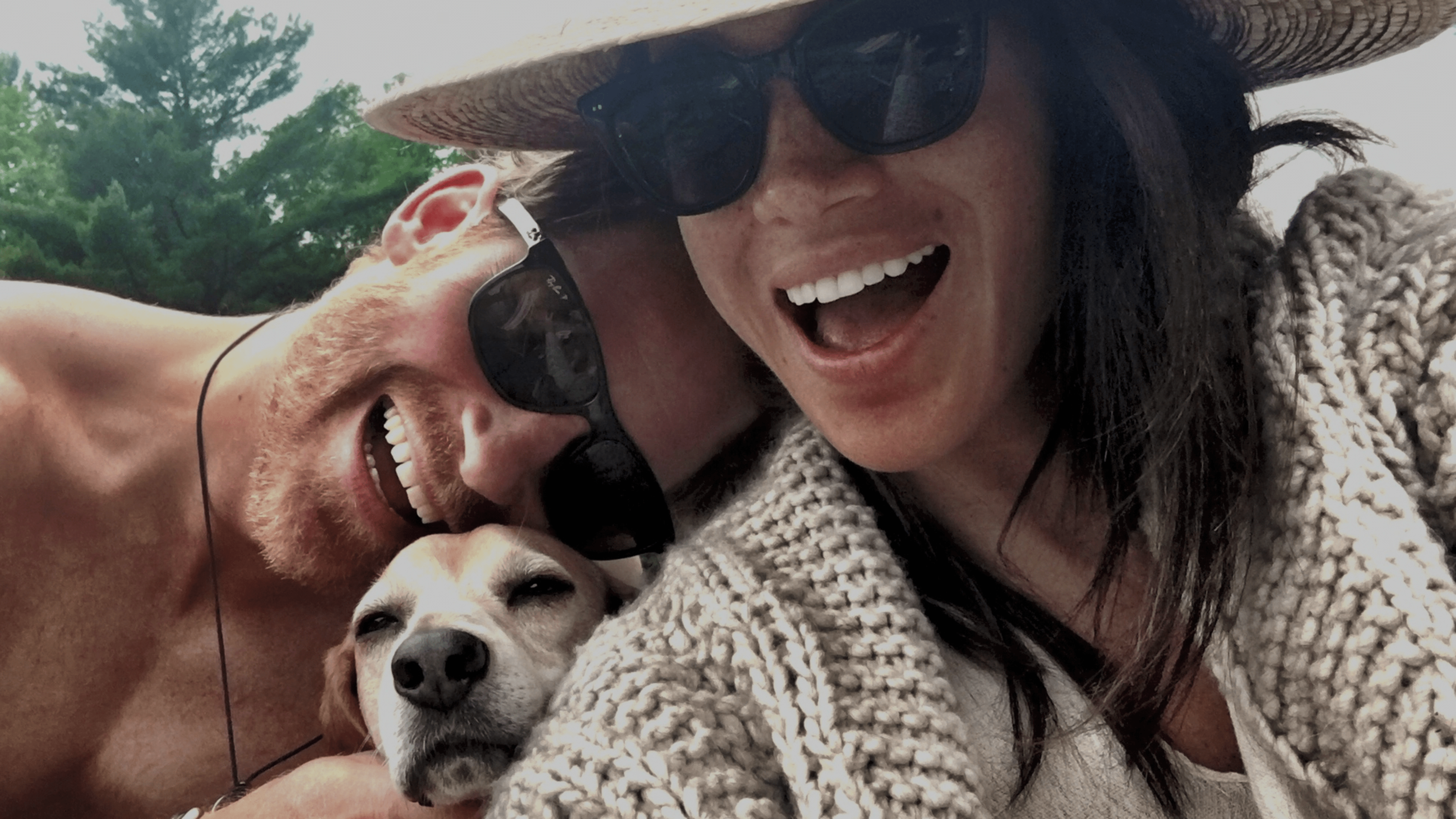 a man and a woman are posing for a picture with a dog