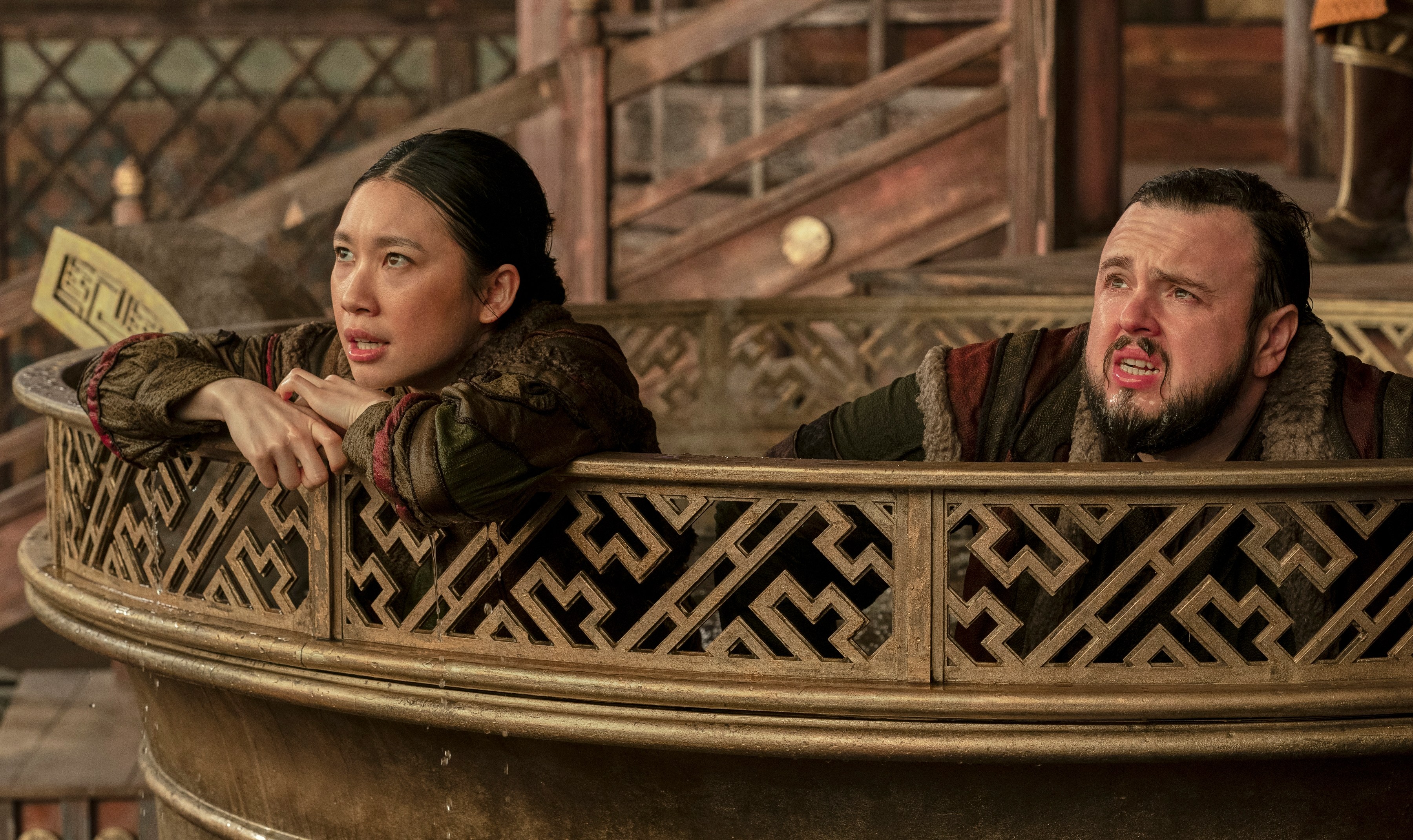 a man and a woman are sitting in a maze looking at something