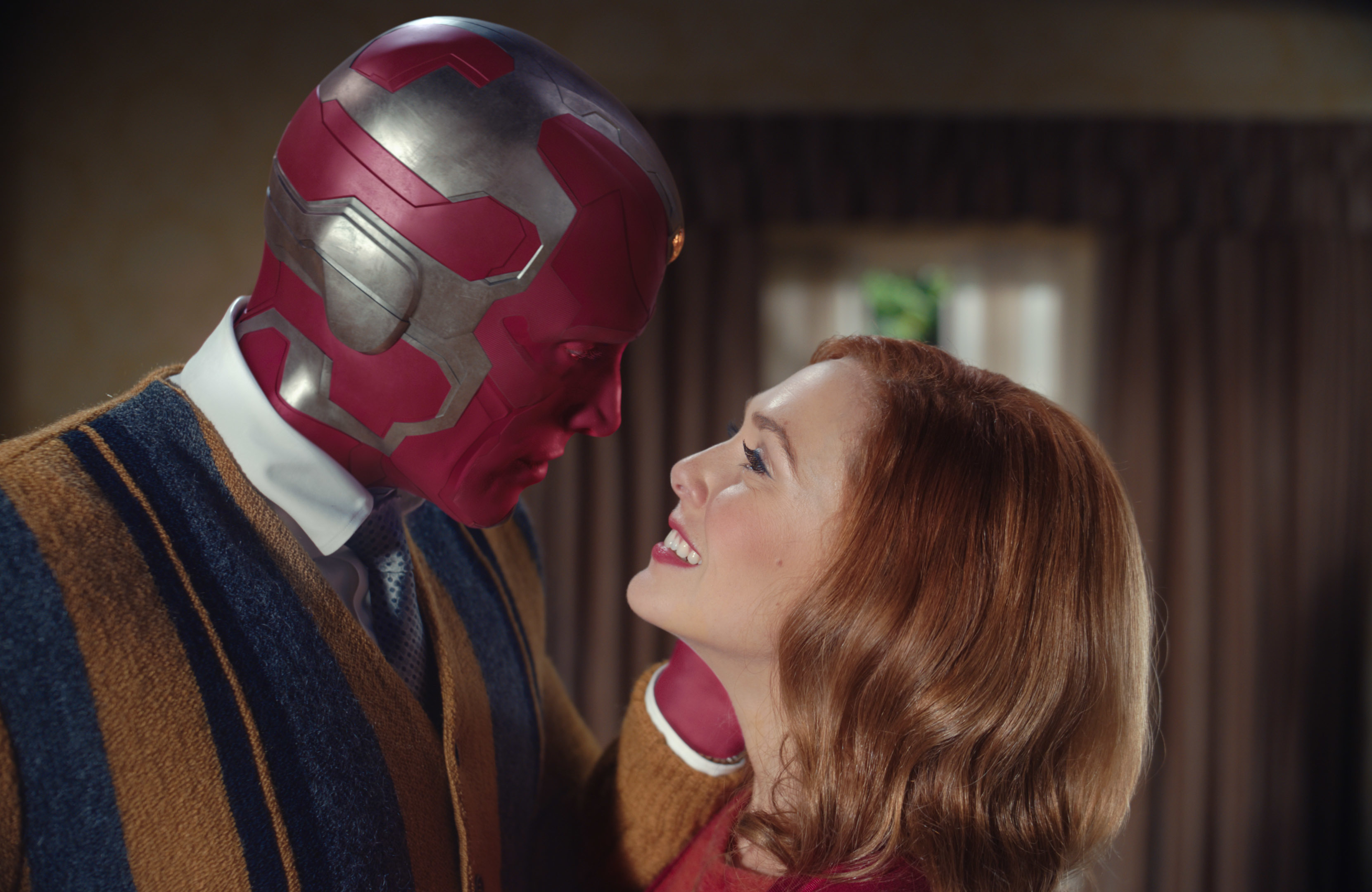 a man with a red helmet and a woman with red hair look at each other