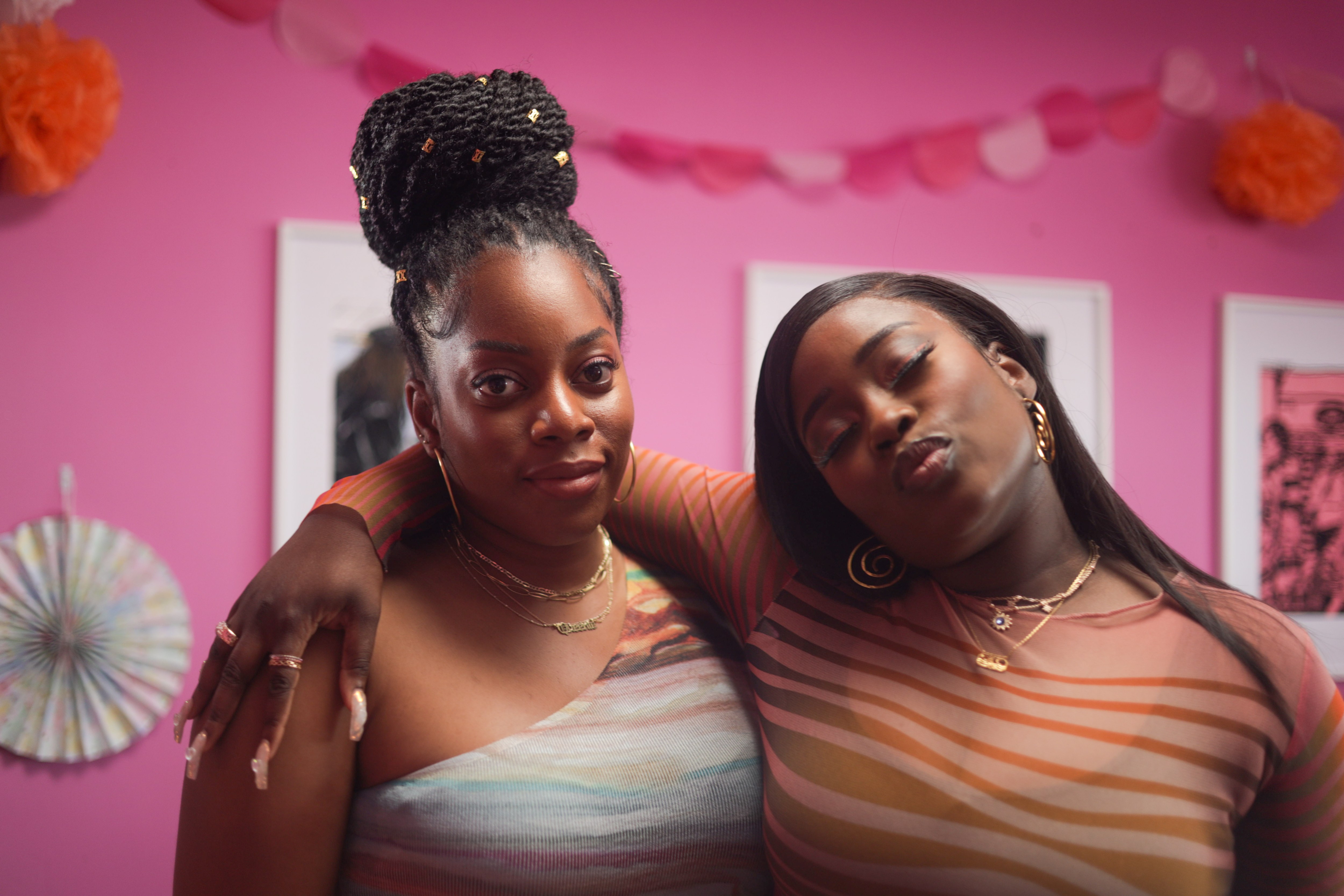 two women standing next to each other with one wearing a necklace that says 'I love you'