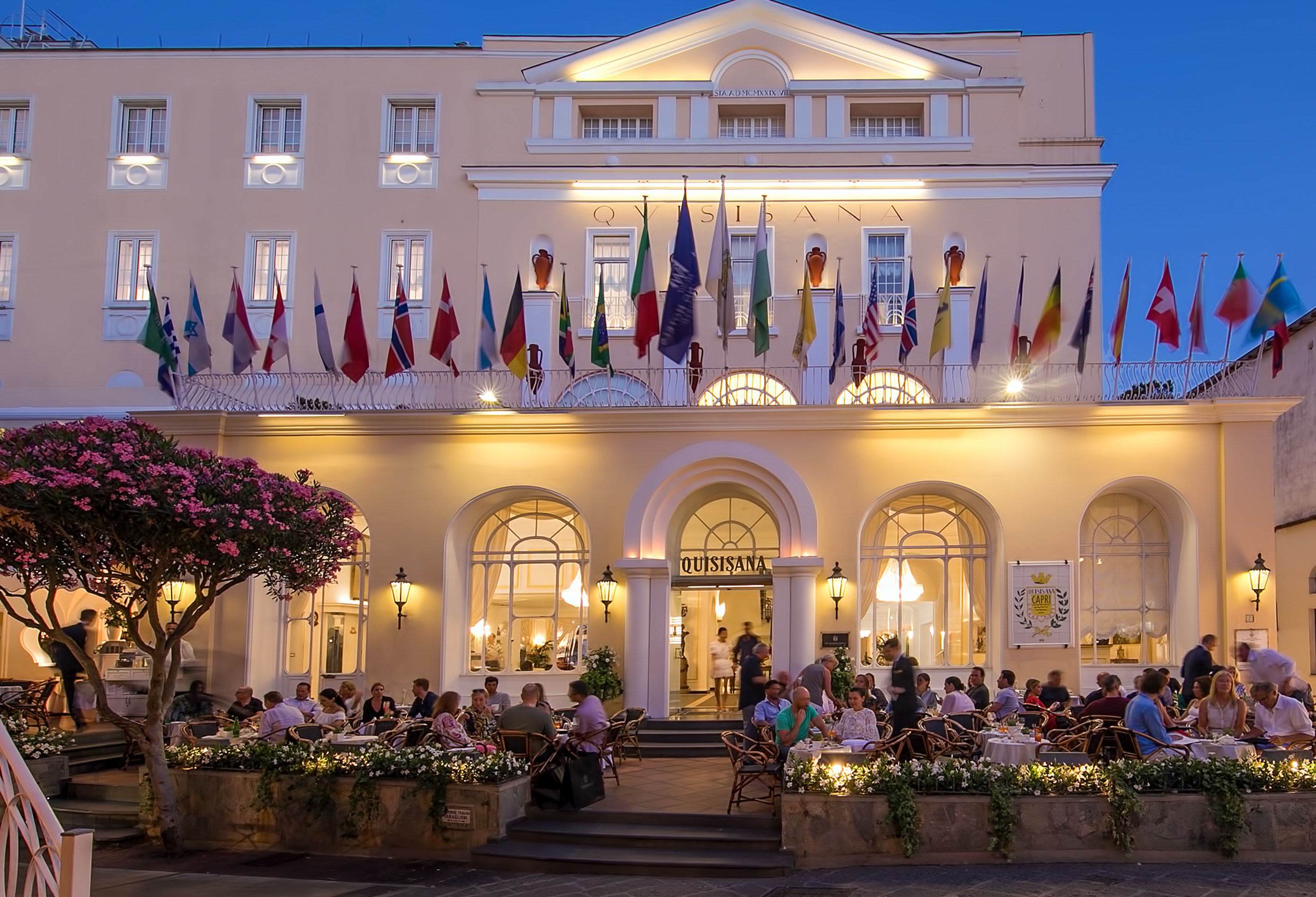 Grand Hotel Quisisana at night, with people dining outside.