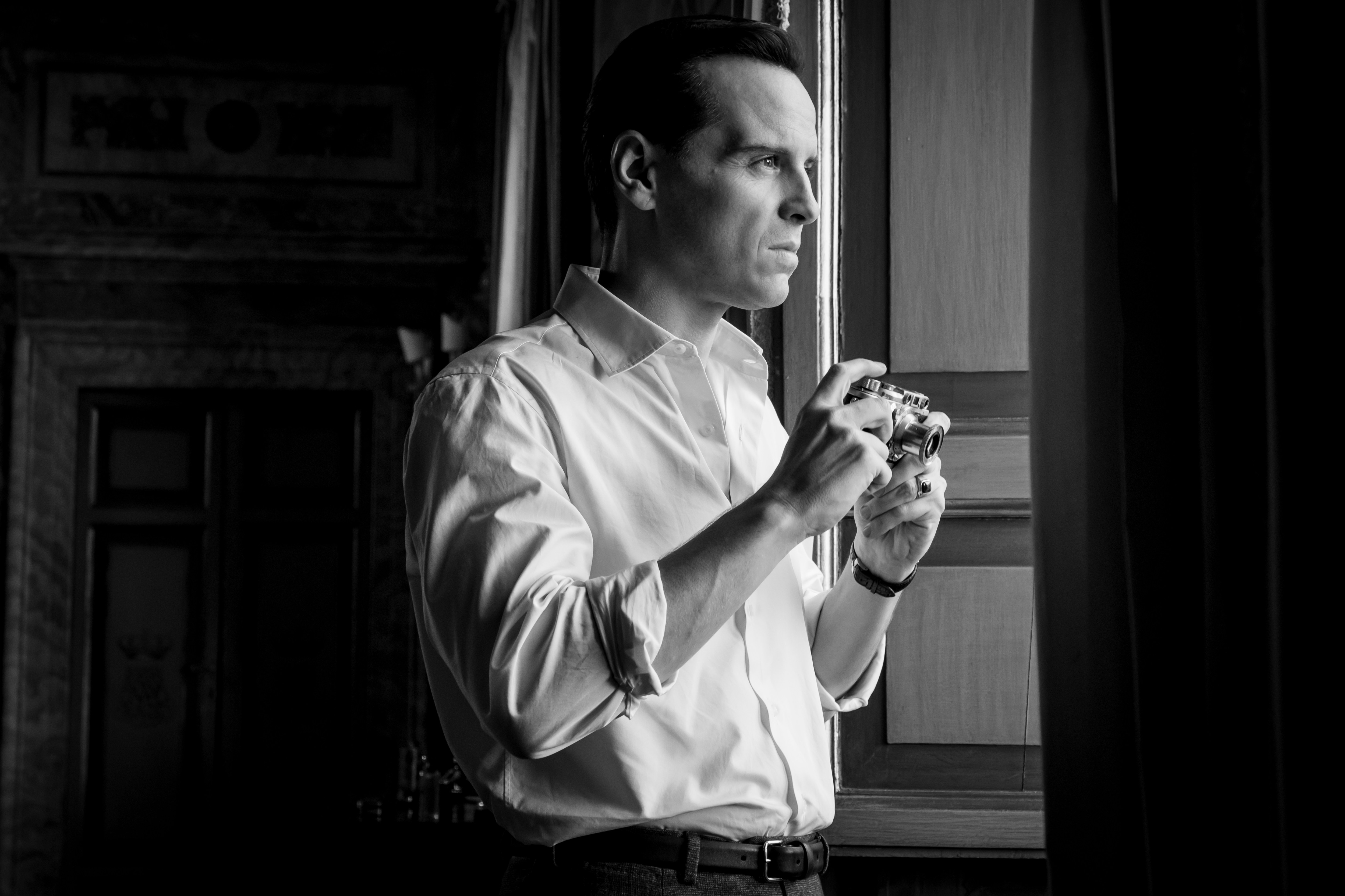 a black and white photo of a man holding a camera